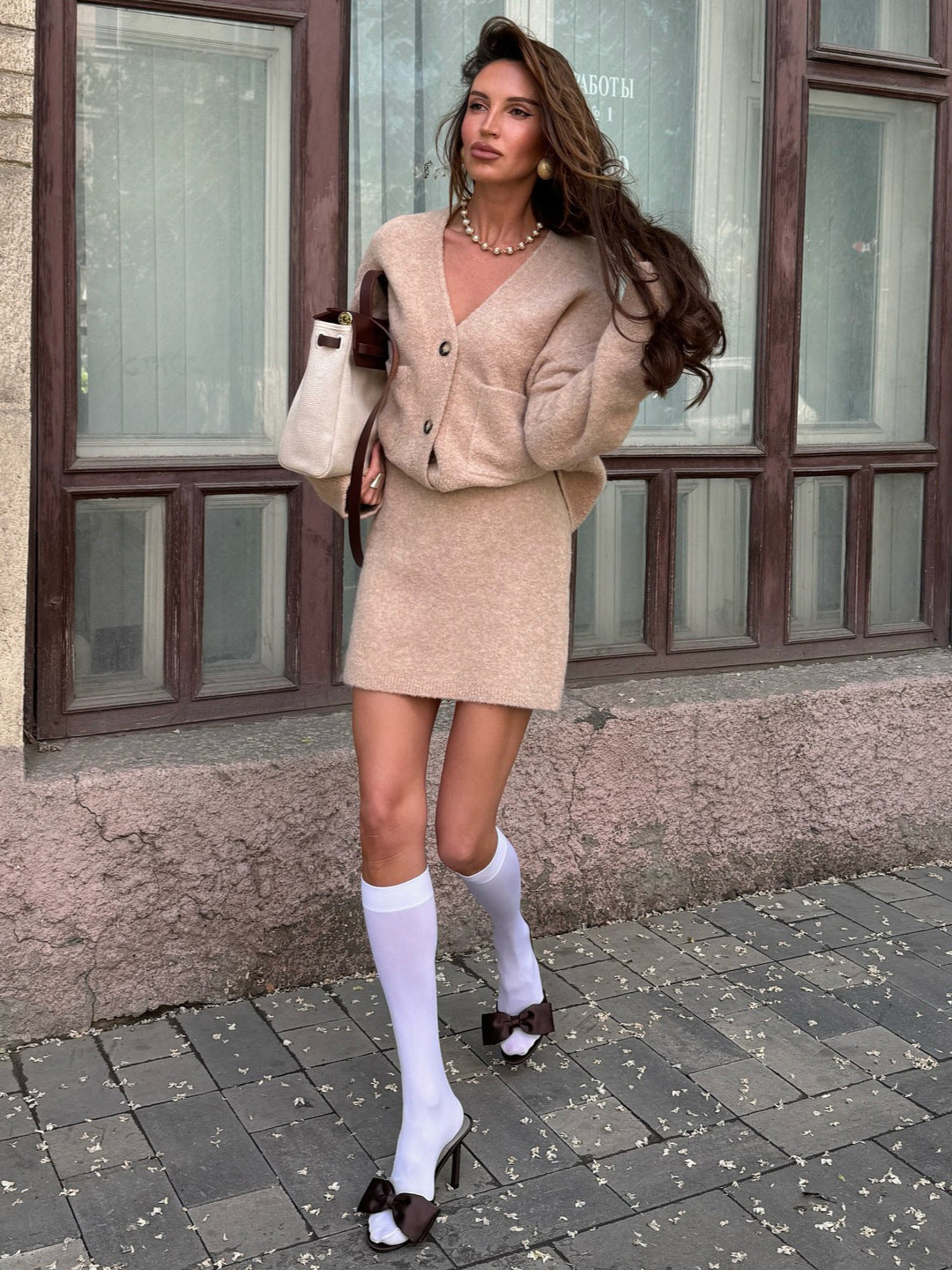 Marelle – kardigan z guzikami, kolor Beż / Beige – ujęcie w ruchu, stylizacja z torebką.