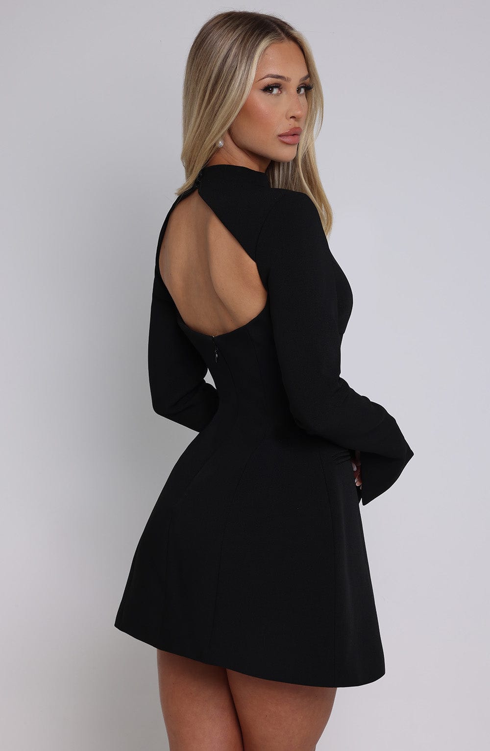 Modelka w czarnej sukience – poza bokiem, elegancki look